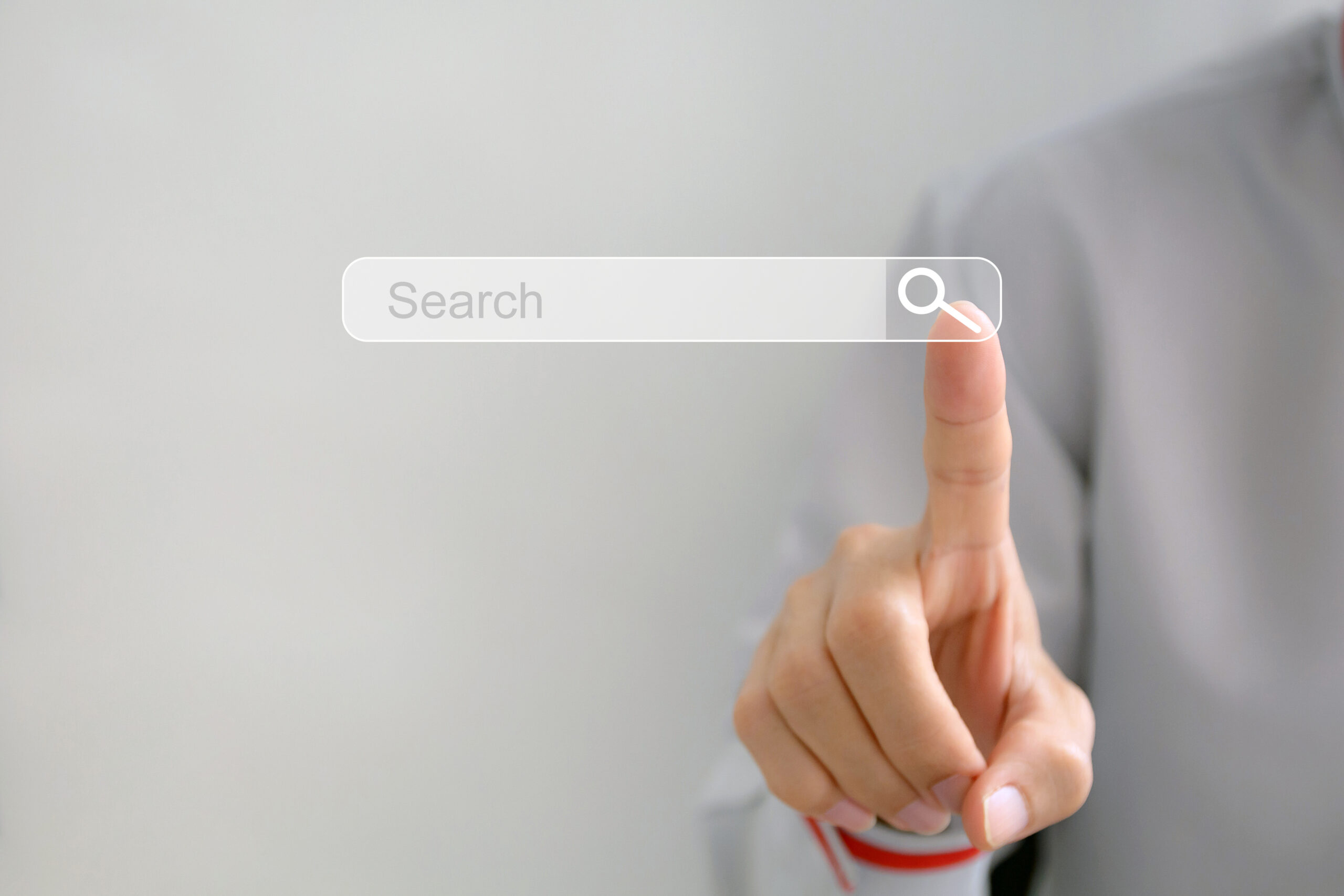 a hand points their index finger towards a floating search bar to abstractly represent the act of using a web search engine