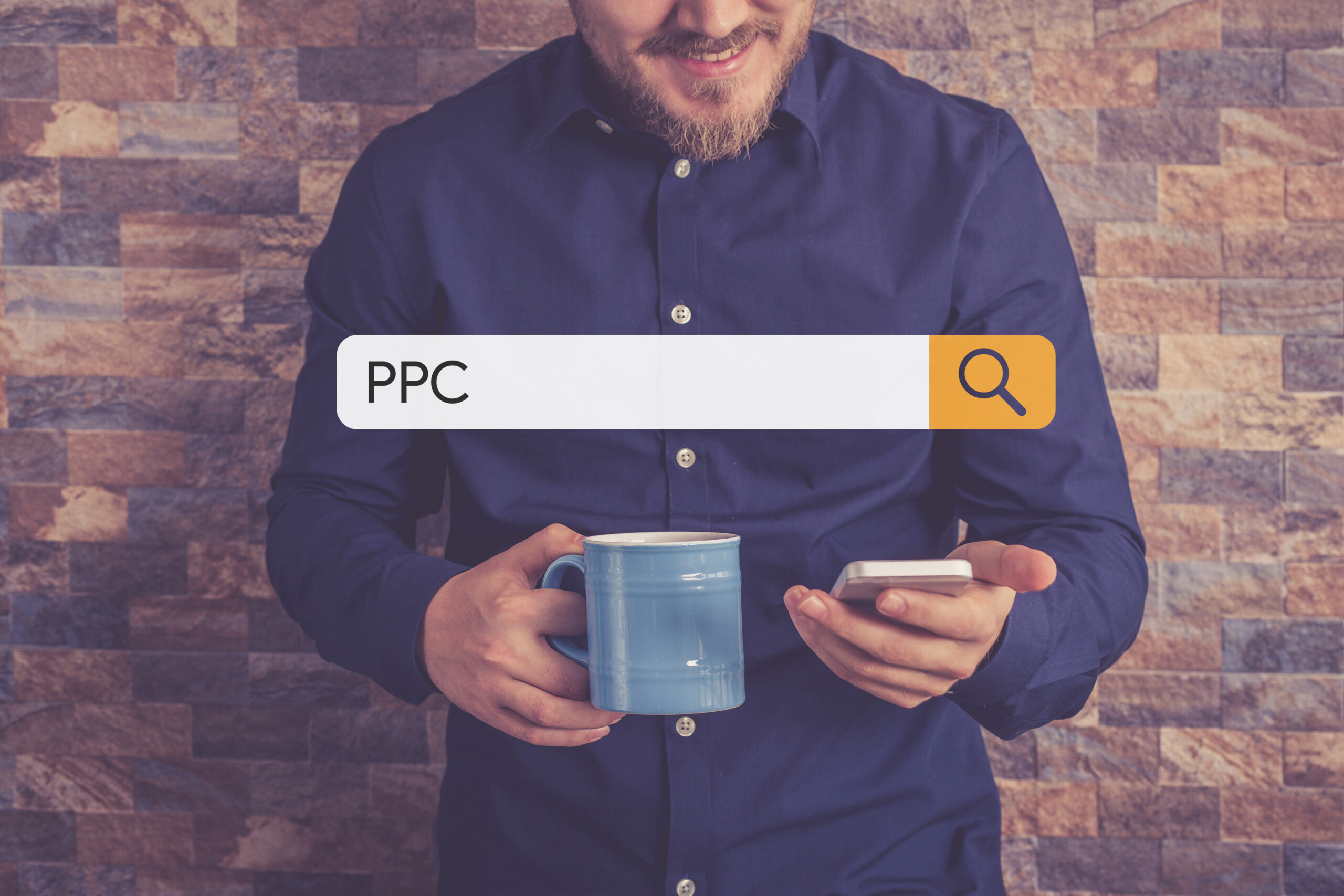 A man is holding his smartphone and smiling at it while holding a coffee in the other hand. A search bar with the phrase "PPC" is graphically laid on top of the image.