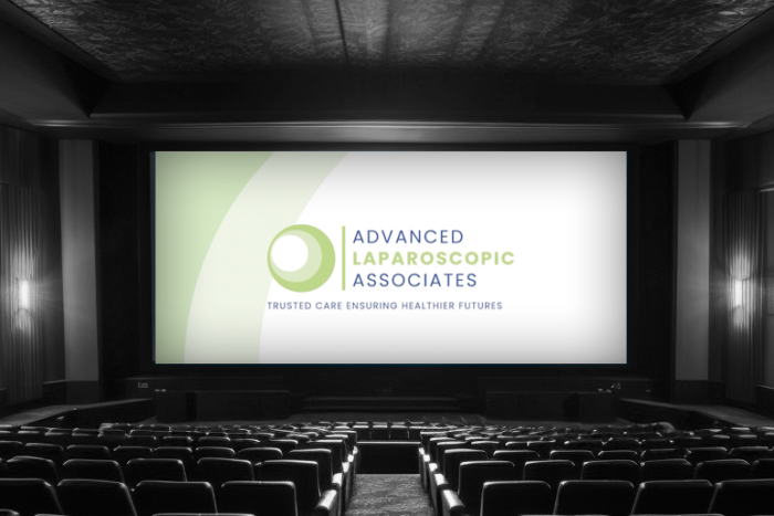 An advertisement is shown on a movie theater screen in an empty theaters